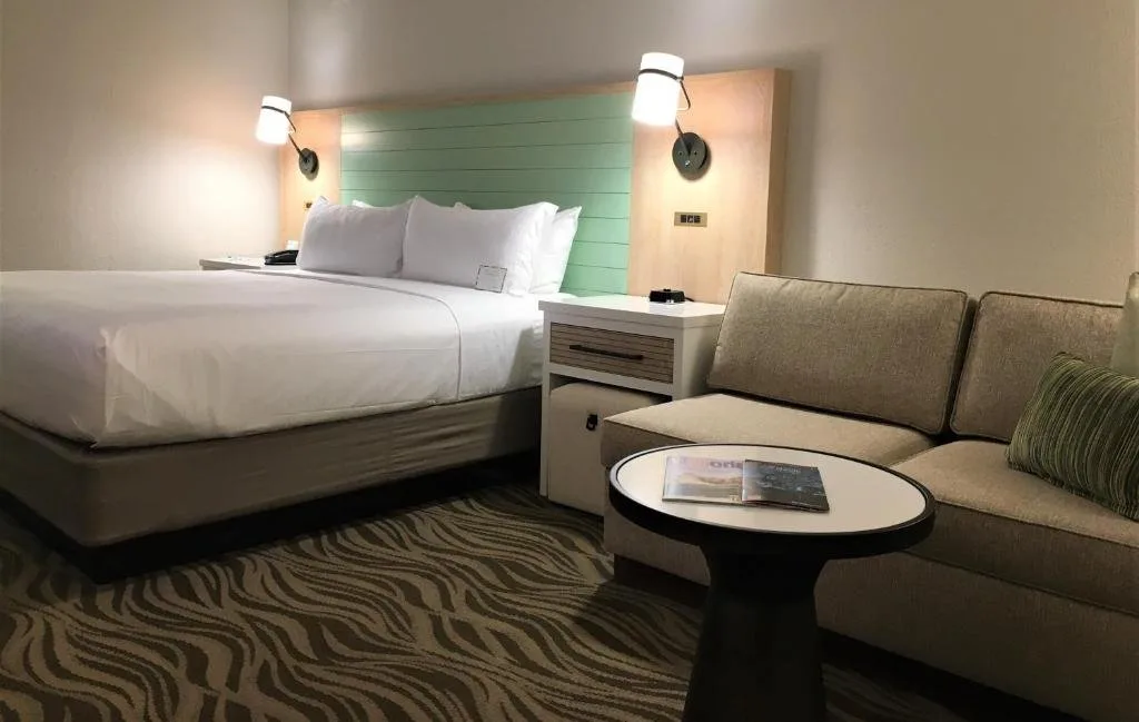 Habitaci&oacute;n con cama grande, sof&aacute; y mesa redonda en Wyndham Garden Lake Buena Vista