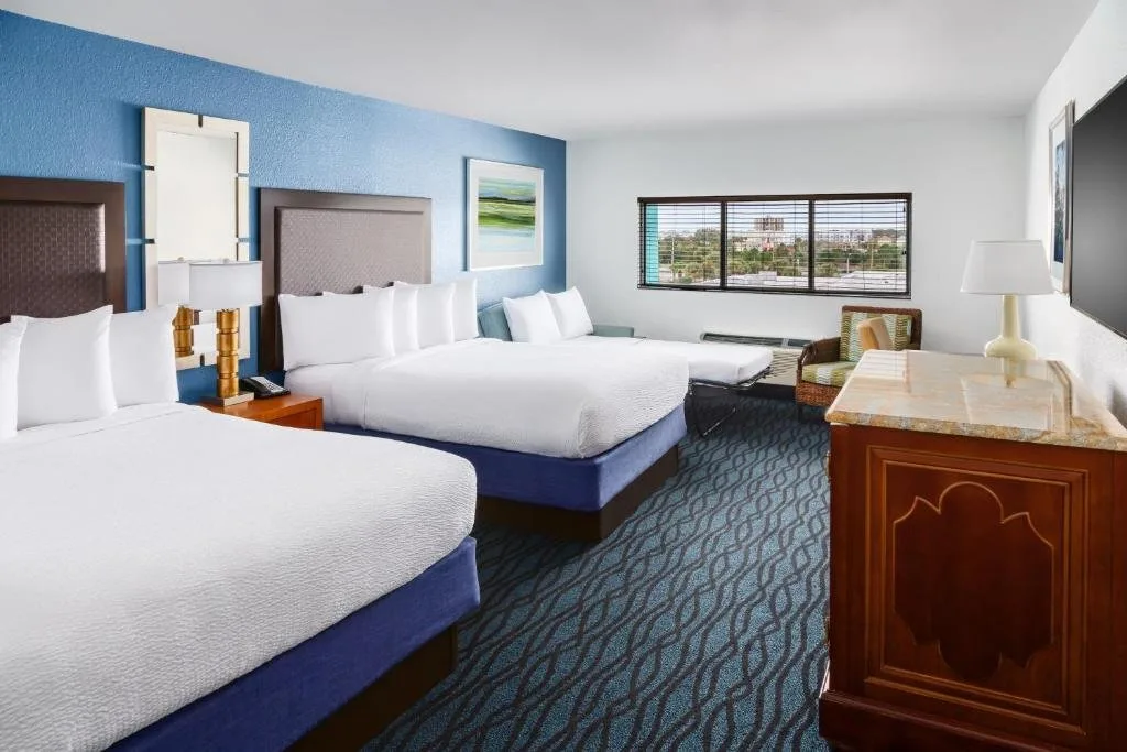 Habitación con dos camas, un sofá cama y una ventana en CoCo Key Hotel