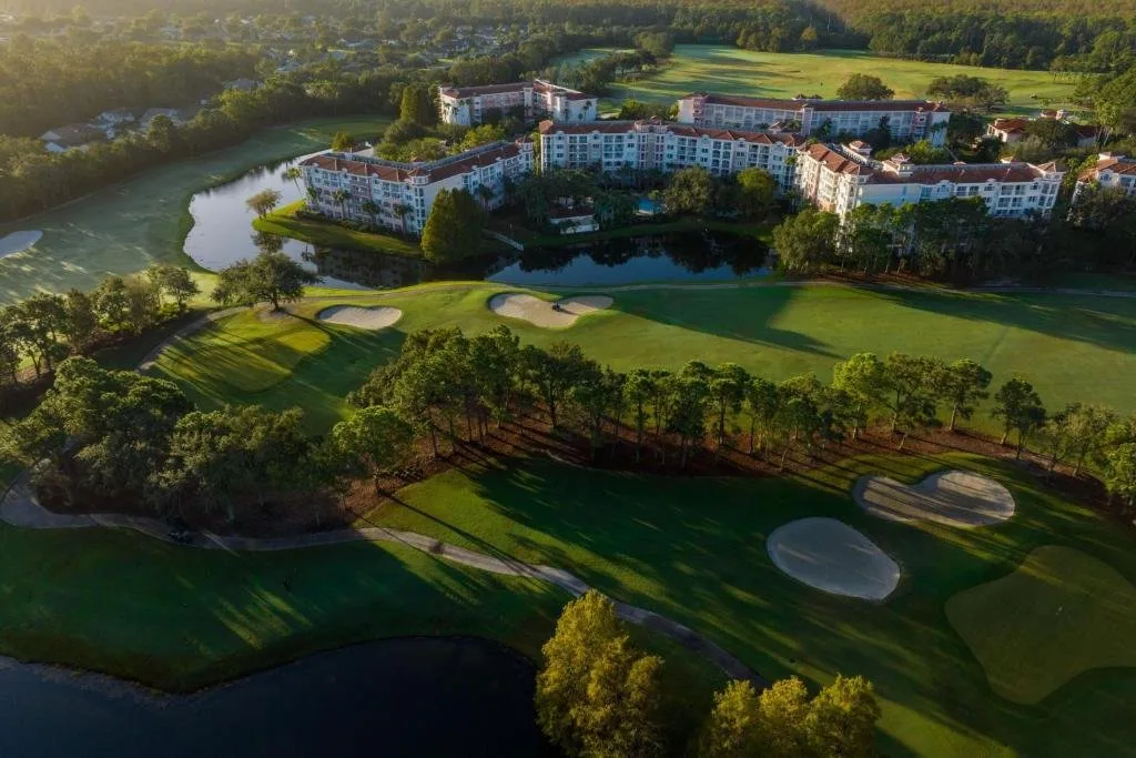 Vista aérea del campo de golf, bunkers de arena, estanque y edificios del complejo en Marriott's Grande Vista