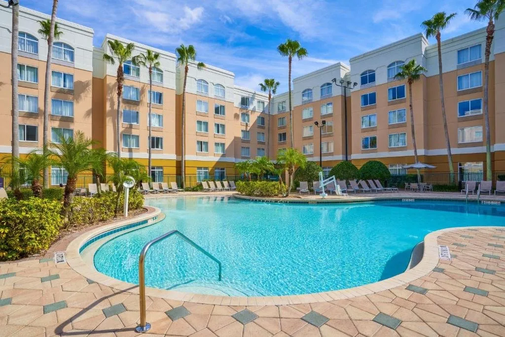 Piscina al aire libre con tumbonas y palmeras en el SpringHill Suites Orlando Lake Buena Vista