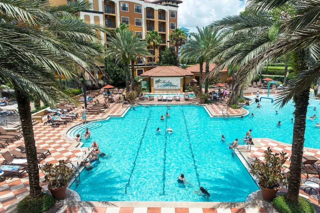 Piscina principal con lap lanes enmarcada por palmeras en Floridays Resort Orlando