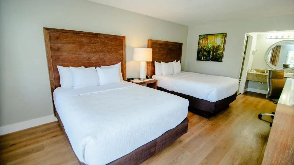 Dos camas con cabeceros de madera altos en Quality Inn & Suites By the Parks