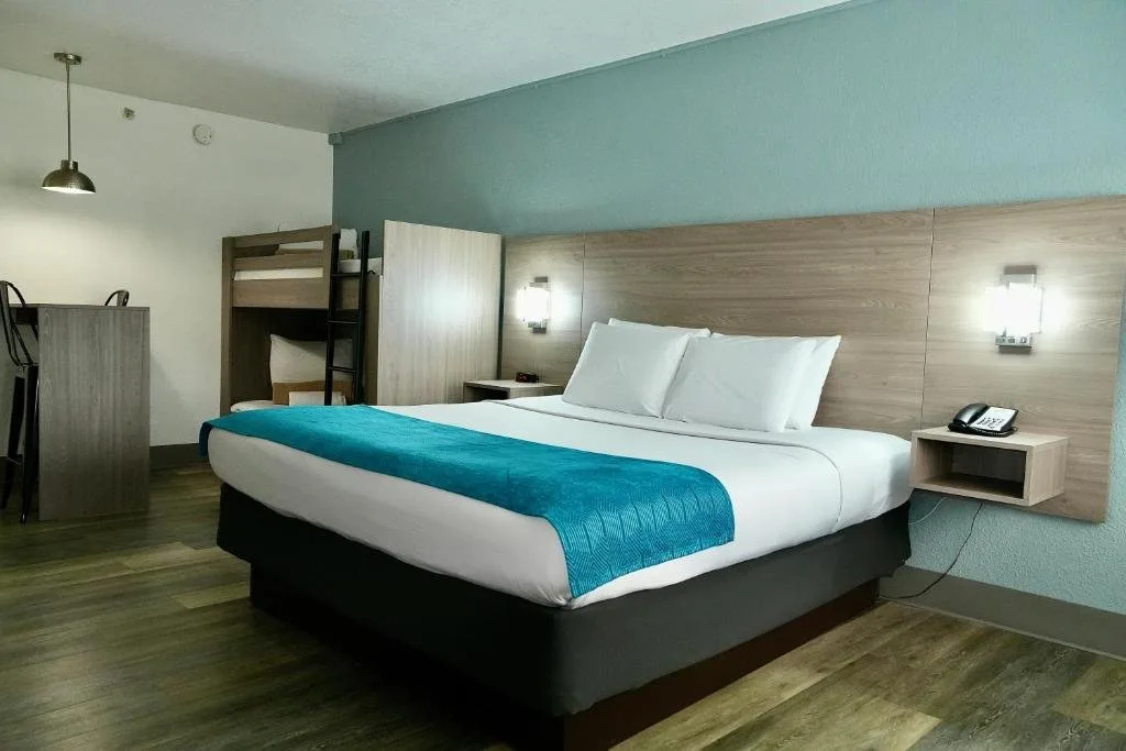 Cama grande con tiro verde azulado y literas en una habitaci&oacute;n de hu&eacute;spedes en CoCo Key Hotel