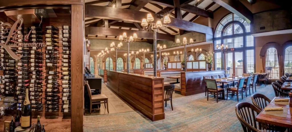 Un asador en Rosen Shingle Creek con una pared de vino y ventanas arqueadas