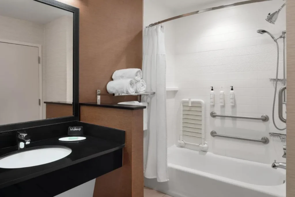 Baño accesible con barras de apoyo, bañera y asiento de ducha plegable en Fairfield Inn & Suites Kissimmee / Celebration
