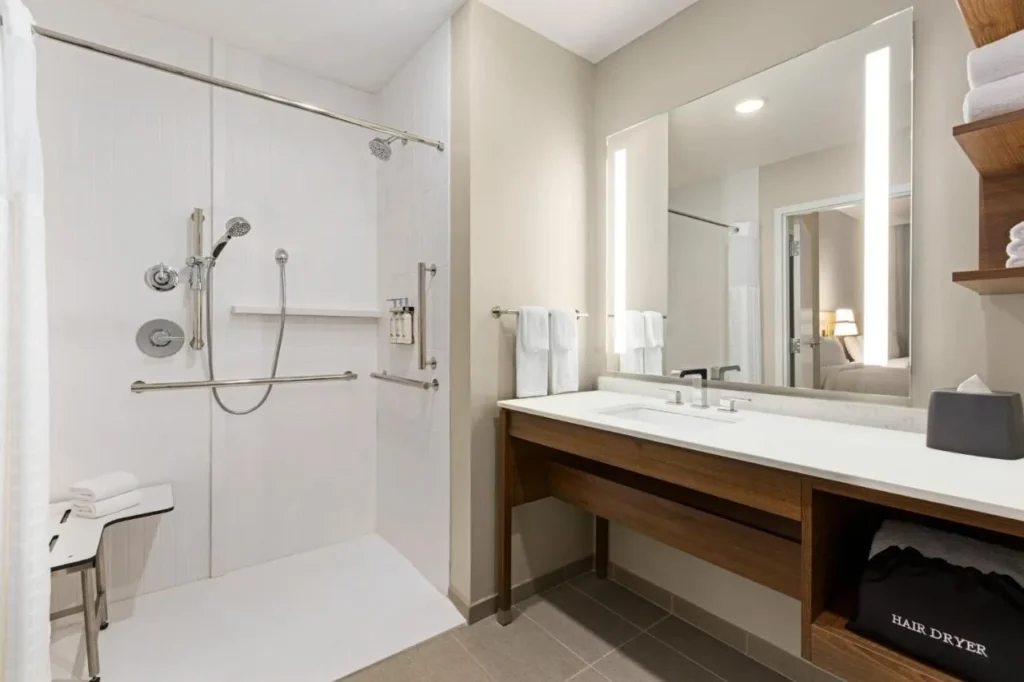 Accessible bathroom with roll-in shower, grab bars and lit mirror at Staybridge Suites Clermont Southeast