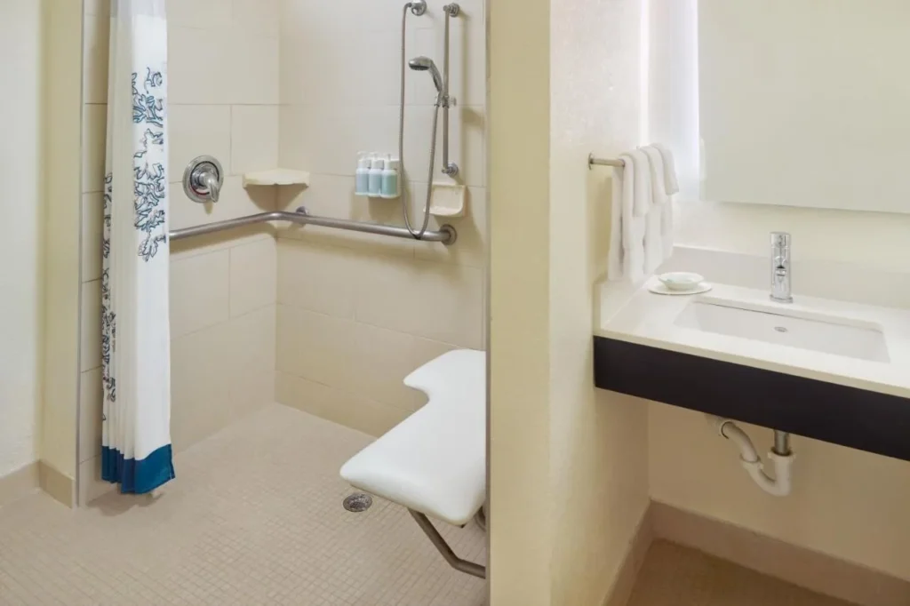 Ducha accesible con asiento plegable y barras de apoyo en el Residence Inn Orlando at SeaWorld