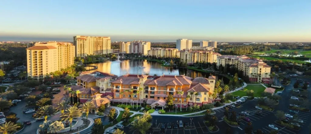 Vista a&eacute;rea al atardecer de las torres Club Wyndham Bonnet Creek alrededor del lago y el edificio principal
