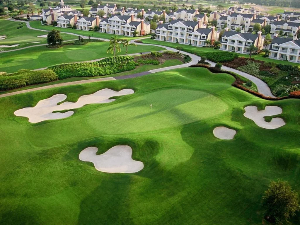 Aerial view of a golf green and bunkers in front of villa buildings at Reunion Resort
