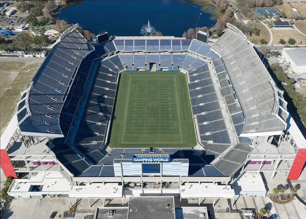 Aerial view of Camping World Stadium in Orlando with its field, stands and a lake behind