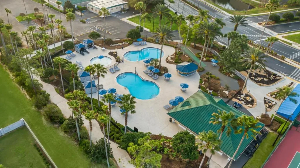 Vista a&eacute;rea de las piscinas del jard&iacute;n, caba&ntilde;as y una cancha de tenis en Mystic Dunes Resort
