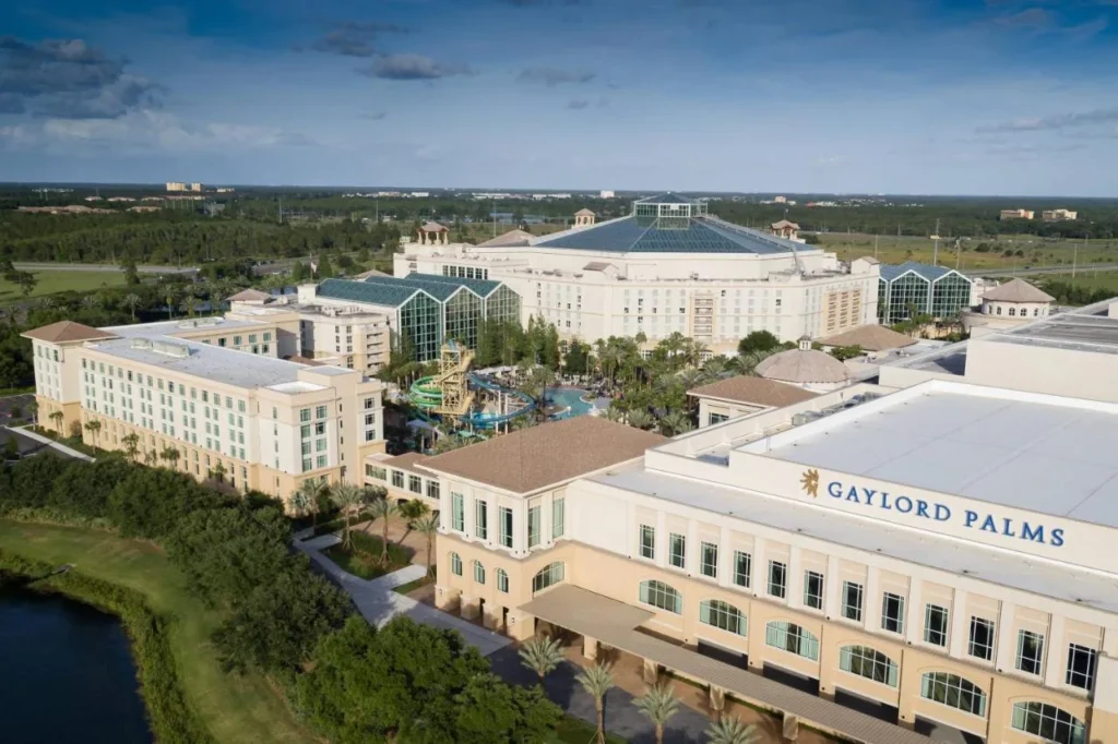 Vista aérea del Gaylord Palms Resort con sus techos de atrio de vidrio, toboganes de agua y cubierta de la piscina