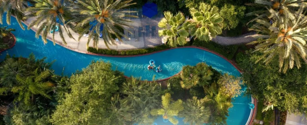 Vista a&eacute;rea de los hu&eacute;spedes en tubos en el r&iacute;o lento palma-sombreado, Omni Orlando Resort at ChampionsGate