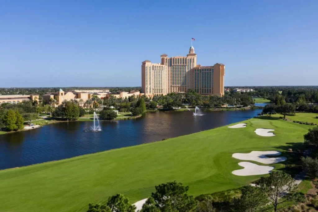 Vista aérea de JW Marriott Orlando Grande Lakes más allá de un lago con fuentes y una calle de golf
