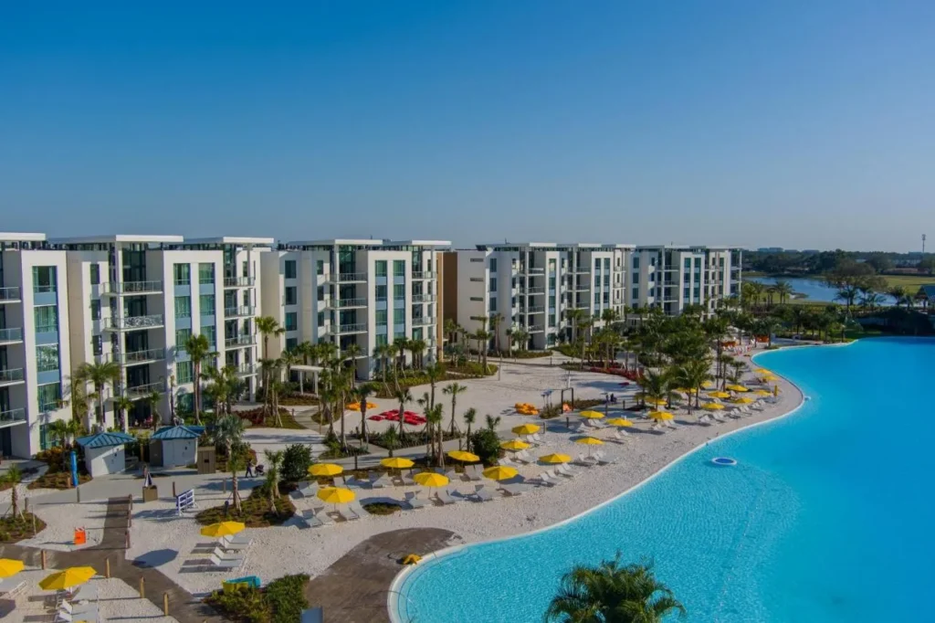 Vista a&eacute;rea de los edificios Flats, playa de arena blanca y la laguna de Evermore Bay en Evermore Orlando Resort