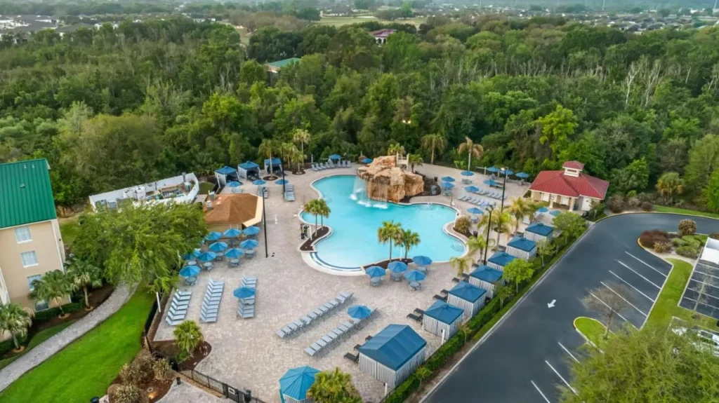 Vista a&eacute;rea de la piscina de la laguna, cascada de roca, caba&ntilde;as y terrenos boscosos en Mystic Dunes
