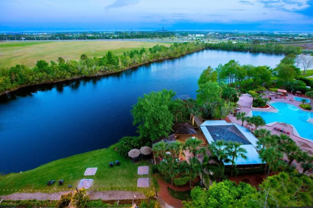 Vista a&eacute;rea del lago, cubierta de la piscina al aire libre y jardines de palmeras junto al Marriott Orlando Airport Lakeside