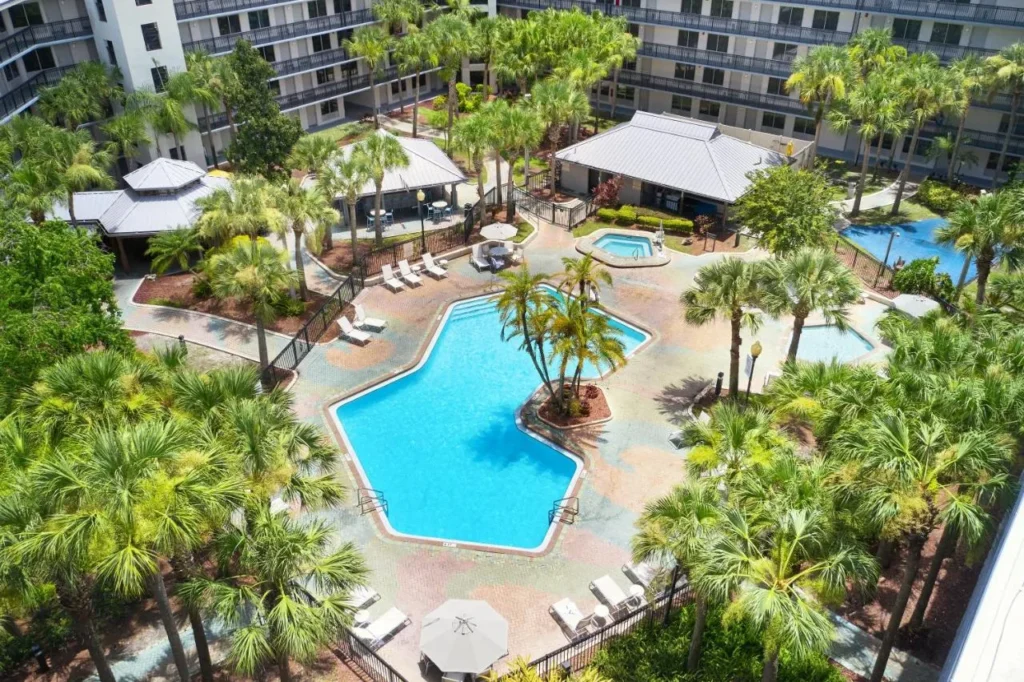 Vista aérea de la piscina del Courtyard con palmeras y bañera de hidromasaje en Staybridge Suites Orlando Royale Parc