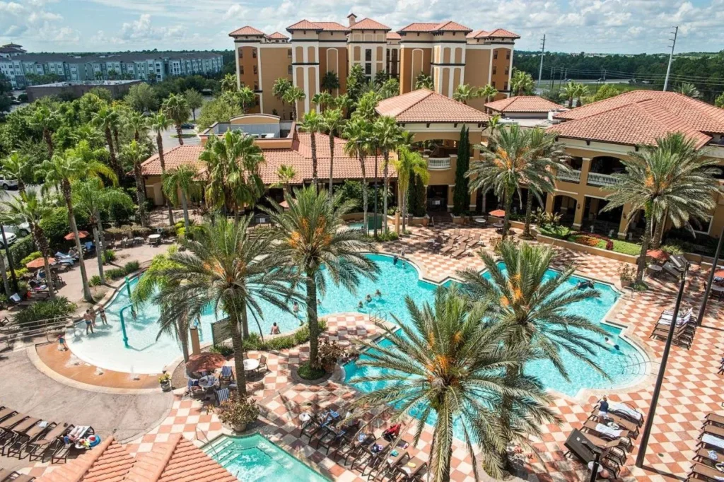 Vista aérea de las piscinas bordeadas de palmeras y el área de chapoteo para niños en Floridays Resort Orlando