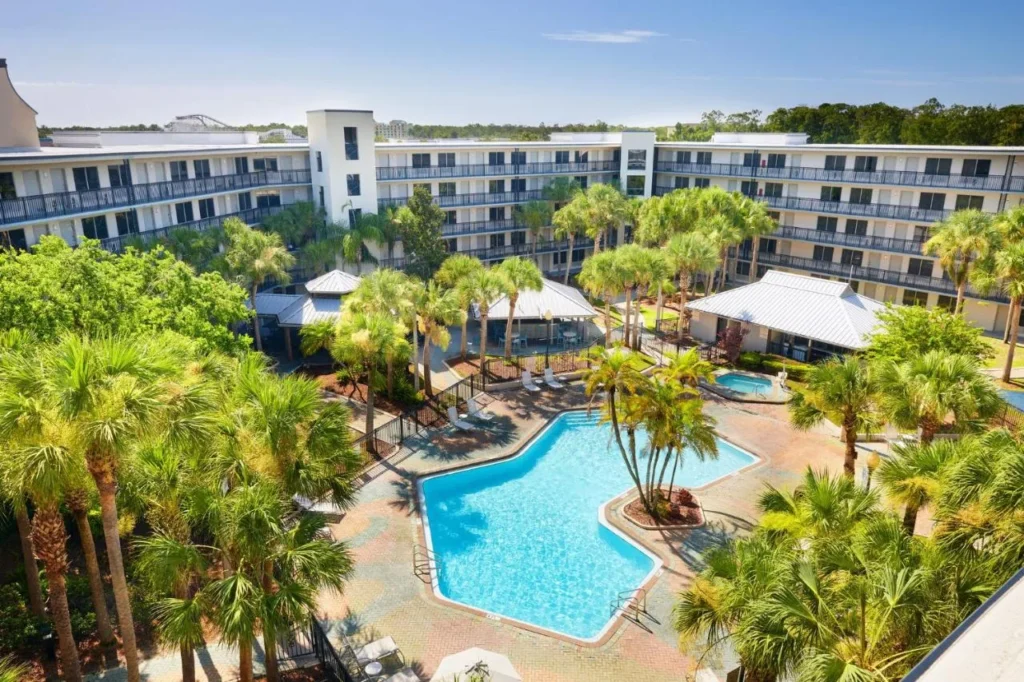 Vista a&eacute;rea de la piscina del Courtyard con sombra de palma en Staybridge Suites Orlando Royale Parc Suites