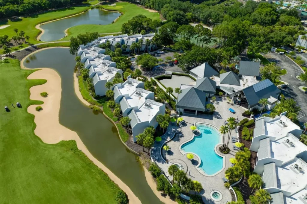 Aerial view of the pool and white-roofed villas beside the golf course at Marriott's Sabal Palms