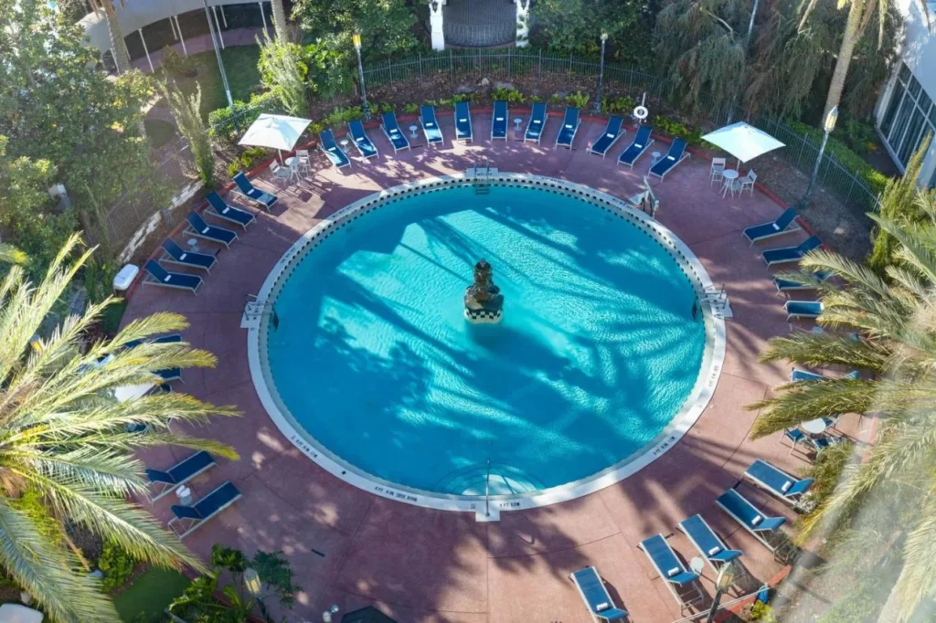 Aerial view of the round pool, fountain and blue loungers at Castle Hotel Orlando