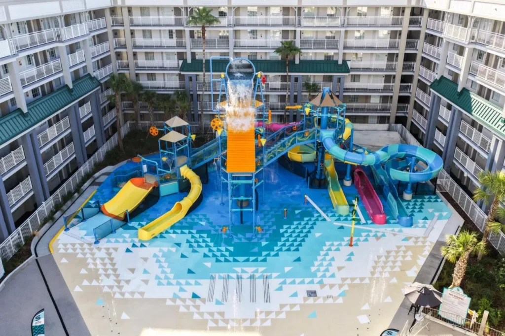 &Aacute;rea de chapoteo de Aqua Cove con cubo basculante y toboganes para ni&ntilde;os en Holiday Inn Resort Orlando Suites