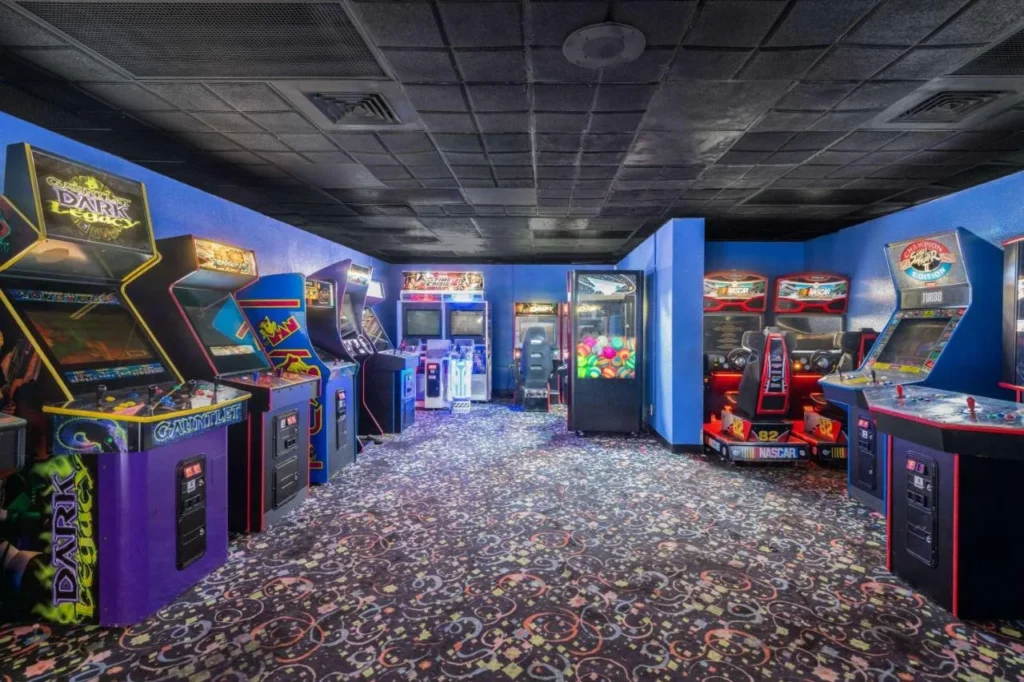 Sala de juegos arcade con gabinetes de juegos de carreras y lucha en Ramada by Wyndham Kissimmee Gateway