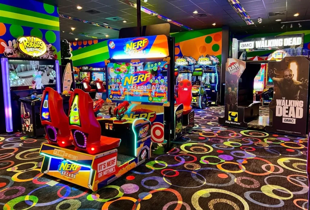 Arcade con tiro y m&aacute;quinas de juego de carreras en la alfombra de colores en Holiday Inn Resort Orlando Suites