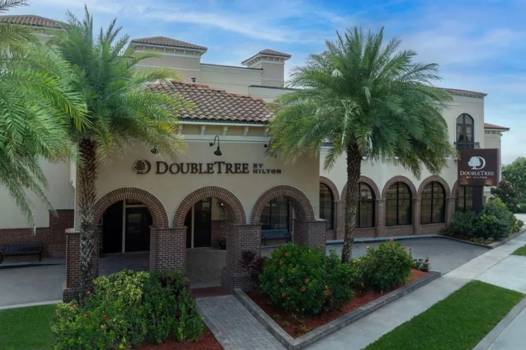 Arched brick entrance, palm trees and sign of DoubleTree by Hilton St. Augustine Historic District
