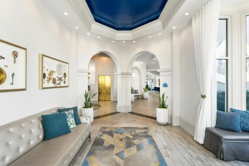 Arched lobby hallway with a gold elevator door and blue ceiling at Castle Hotel Orlando