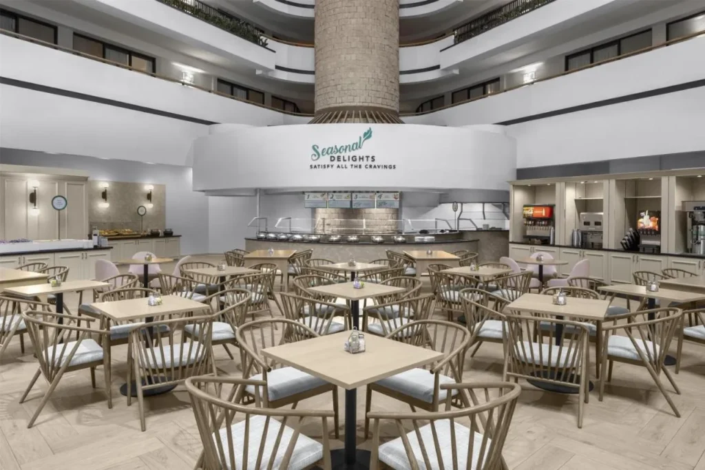 Atrium breakfast area with tables and the Seasonal Delights buffet at Embassy Suites ICON Park