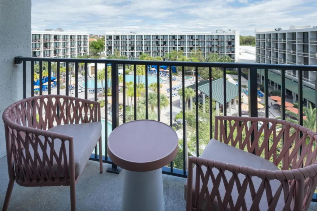 Balc&oacute;n con dos sillas con vistas al Courtyard de la piscina en Sheraton Lake Buena Vista Resort