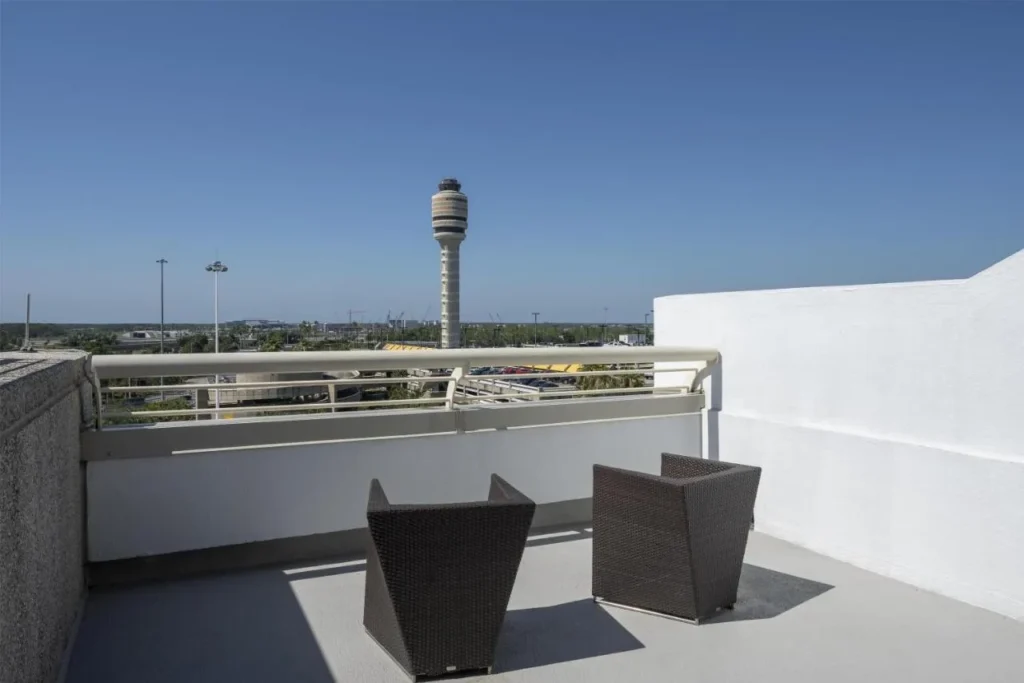 Balcony with two wicker chairs facing the MCO control tower at Hyatt Regency Orlando International Airport