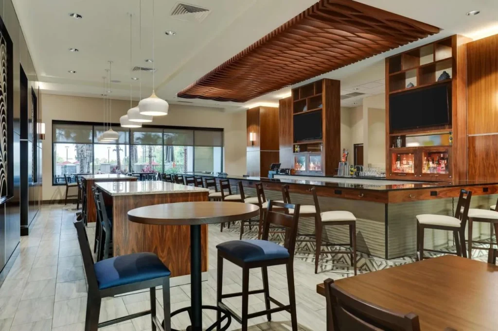 Bar and dining area with high-top tables under a wood ceiling at Drury Plaza Hotel Orlando