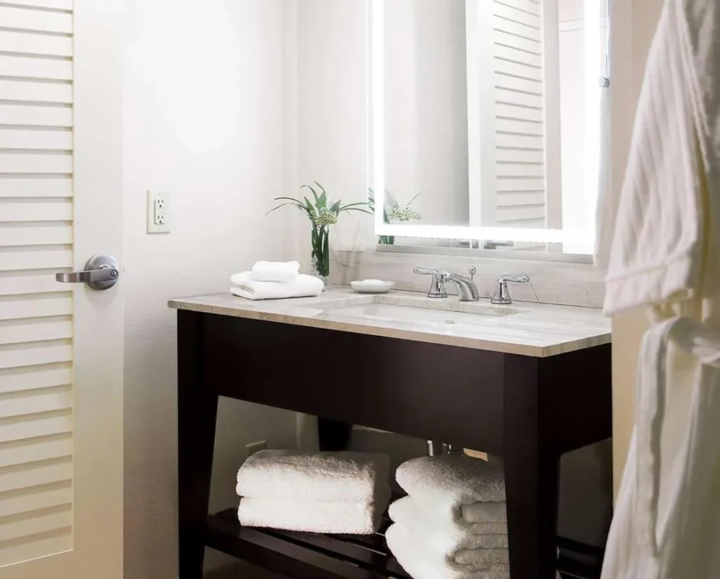Bathroom vanity with a lit mirror and stacked towels, Hilton Orlando Buena Vista Palace