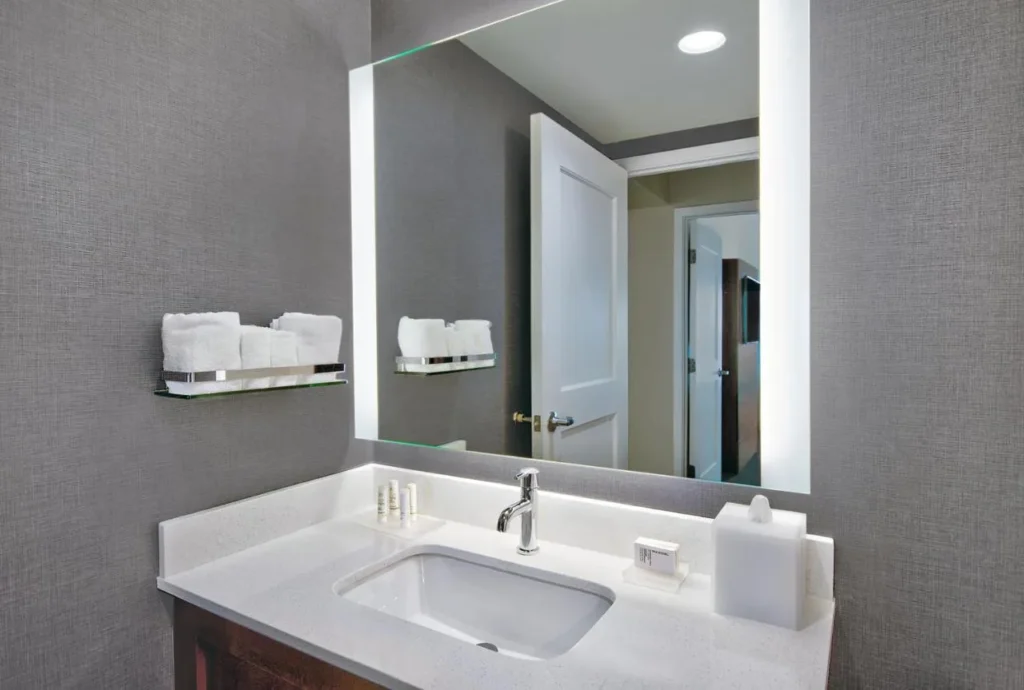 tocador de ba&ntilde;o con espejo retroiluminado y estante para toallas en el Residence Inn Flamingo Crossings