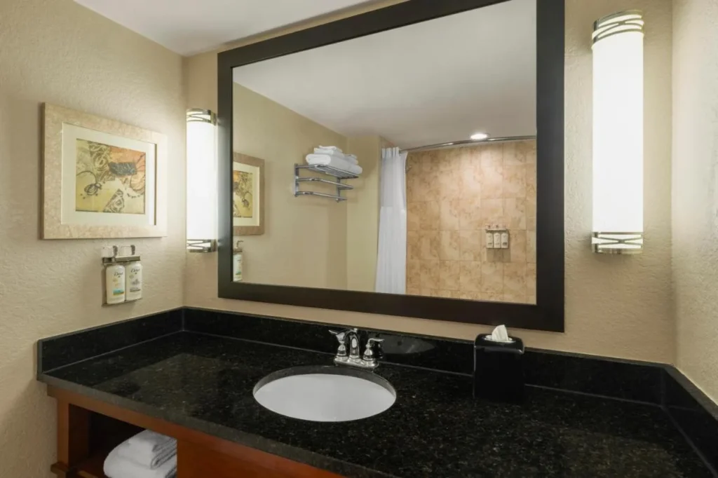 tocador de ba&ntilde;o con encimera de granito y espejo grande en Holiday Inn Resort Orlando Lake Buena Vista