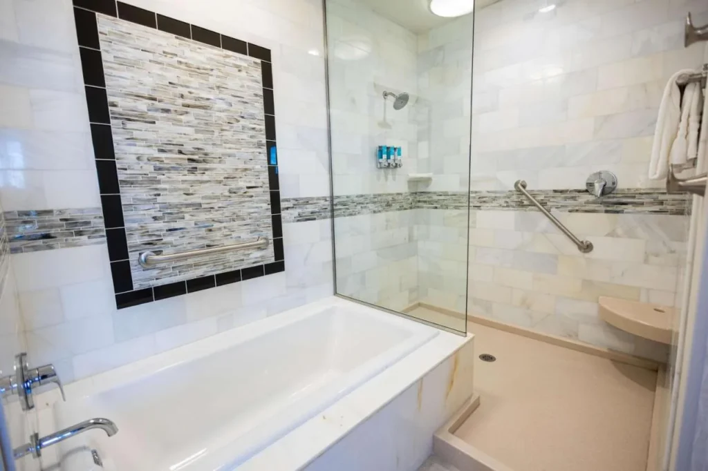 Baño con bañera y ducha de vidrio sin escalón en Drury Plaza Hotel Orlando