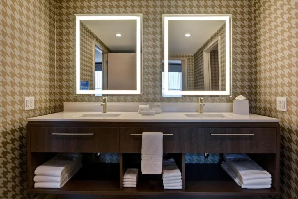 Cuarto de baño con tocador doble y espejos iluminados en Home2 Suites Flamingo Crossings