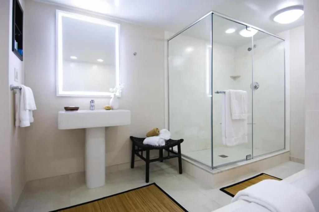 Cuarto de ba&ntilde;o con ducha a ras de suelo de cristal y lavabo en el Hilton Orlando Buena Vista Palace