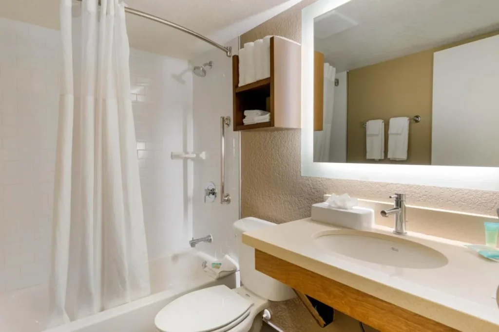 Bathroom with a tub-shower, grab bar and lit mirror at Staybridge Suites Orlando Royale Parc