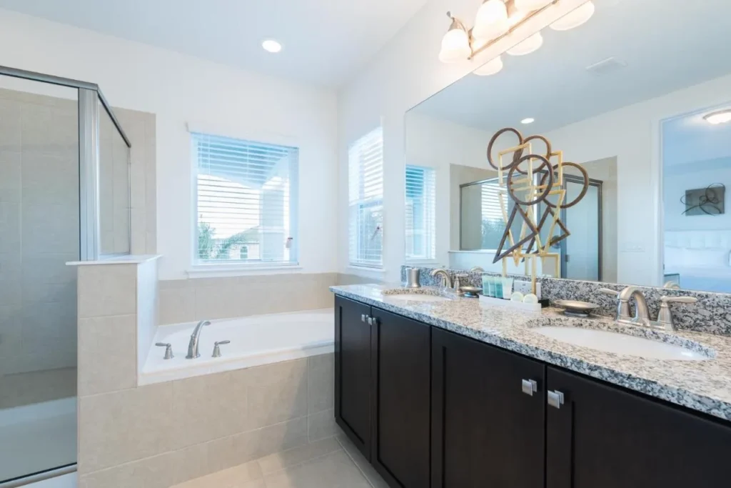 Bathroom with double vanity, soaking tub and glass shower in an Encore Resort home