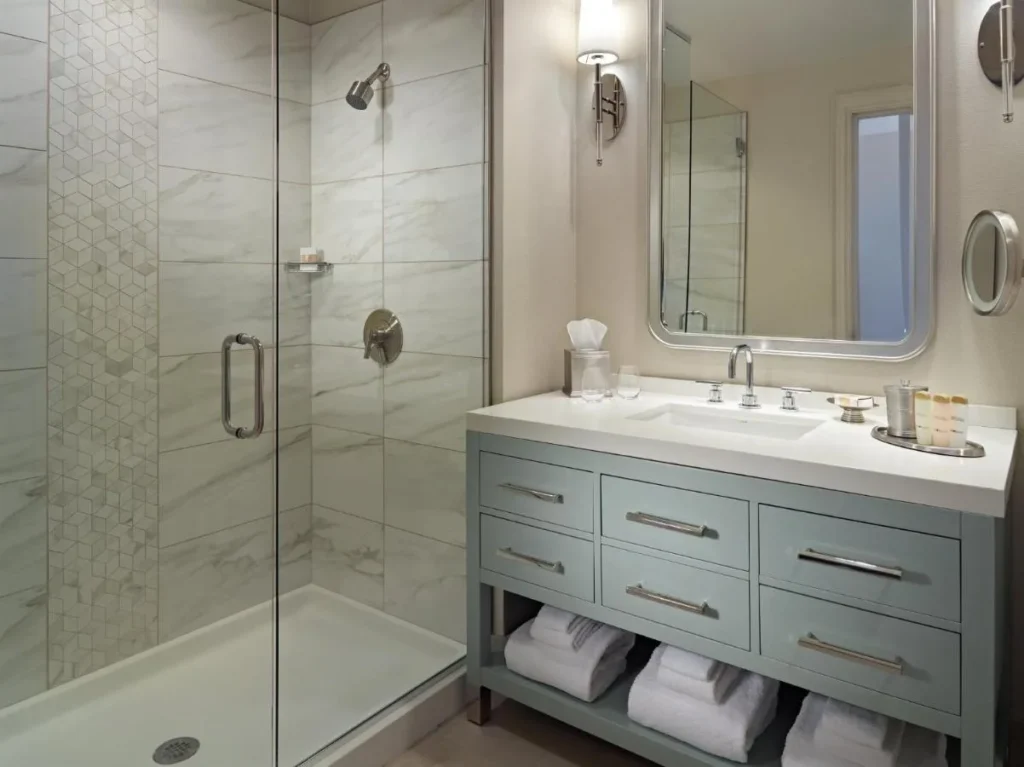 Cuarto de ba&ntilde;o con ducha acristalada y tocador azul p&aacute;lido en Omni Orlando Resort at ChampionsGate
