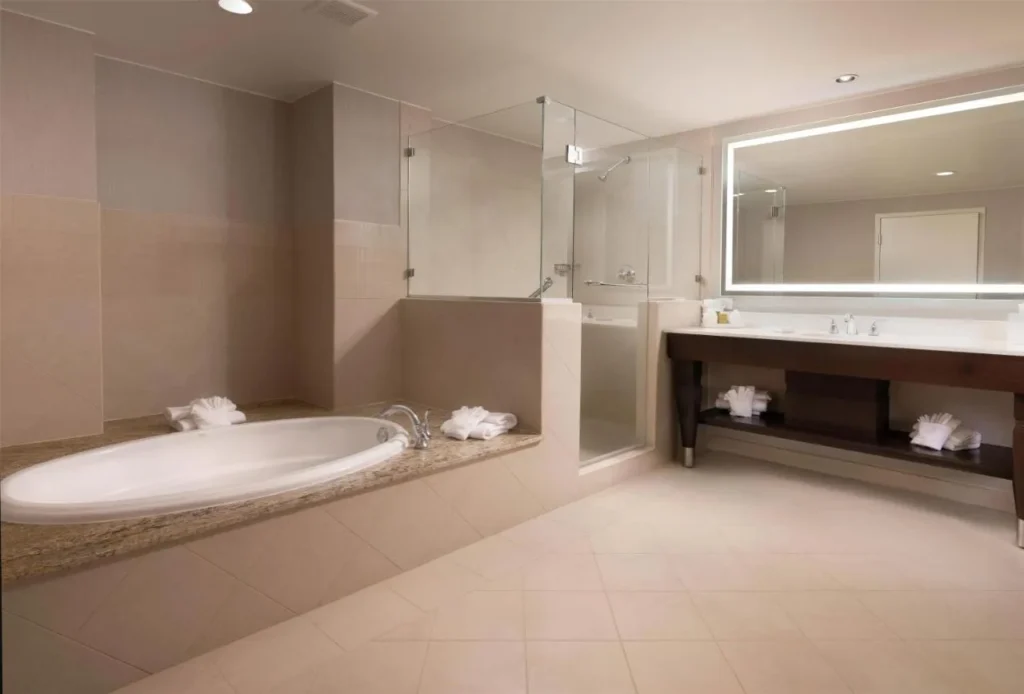 Cuarto de baño con bañera, ducha de cristal y tocador doble en Signia by Hilton Orlando Bonnet Creek