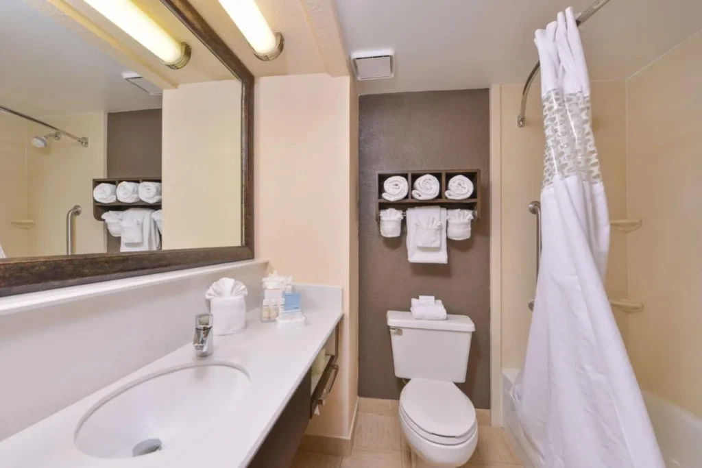 Bathroom with vanity, tub, curved shower rod and grab bars at Hampton Inn Closest to Universal