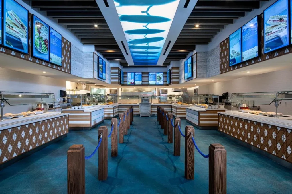 Pista de comida Beach Break Café en Surfside Inn and Suites con un techo de surfista retroiluminado
