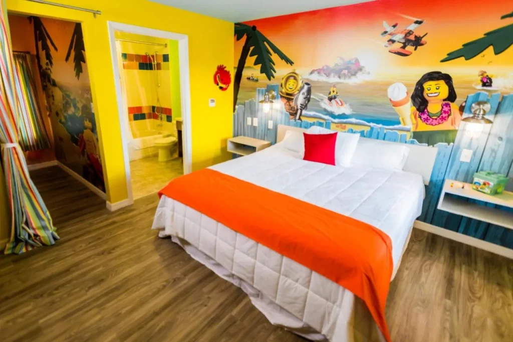 Beach-themed bungalow bedroom with king bed and LEGO mural at LEGOLAND Beach Retreat