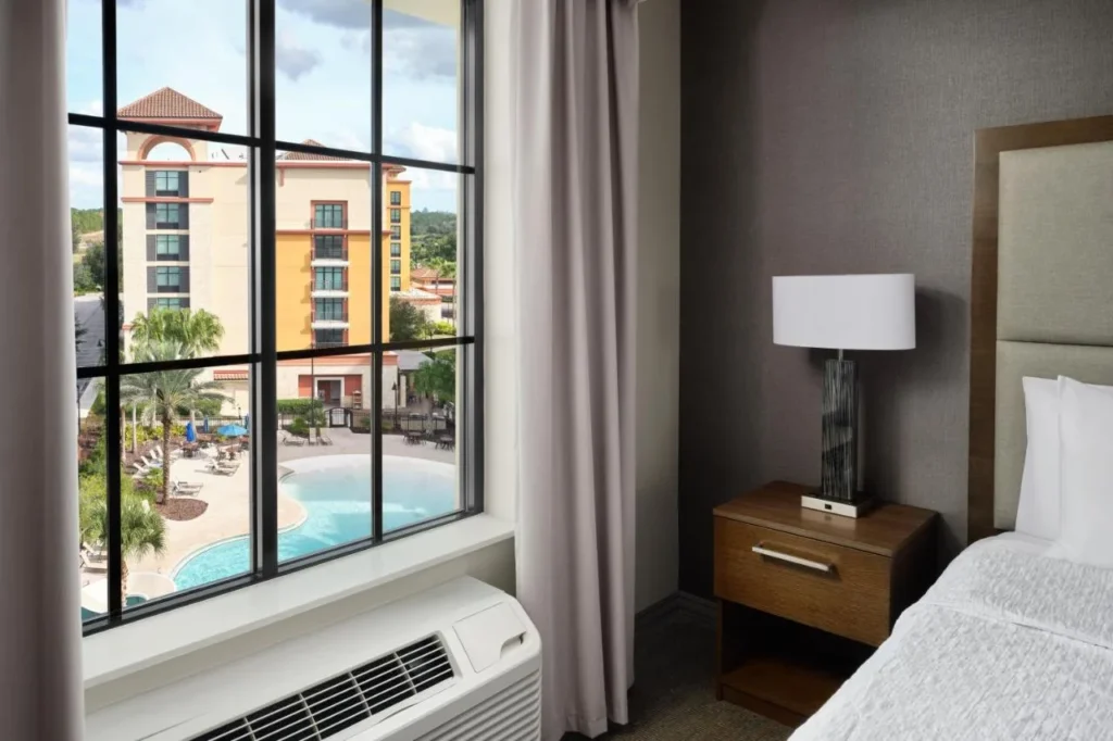 Bedroom window overlooking the pool and neighboring buildings at Homewood Suites Flamingo Crossings