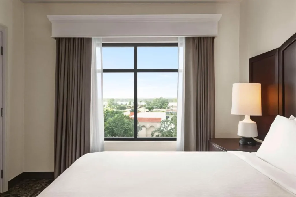 Vista de la ventana del dormitorio de los &aacute;rboles y los tejados de tejas rojas en Embassy Suites Lake Buena Vista South